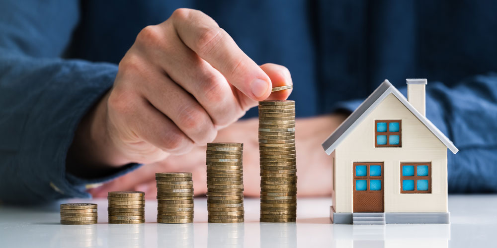 Counting coins next to model home